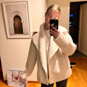Vit ulljacka med dragkedja - Säljer en stilren vit ulljacka med dragkedja och bred krage. Jackan har en oversized passform och är perfekt för kyligare dagar. Den är både snygg och bekväm, och passar bra till olika outfits.