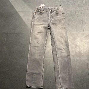 Grå Levis 501 jeans - Säljer ett par klassiska grå Levis 501 jeans. De har en straight passform och är tillverkade i bomull. Perfekta för en avslappnad stil med en tidlös look.