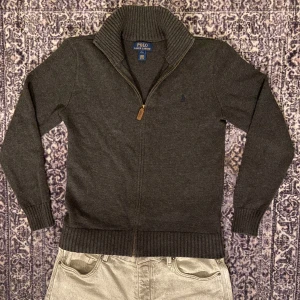 Mörkgrå kofta från Ralph Lauren - Snygg mörkgrå kofta från Ralph Lauren med dragkedja och ribbad krage. Inga fläckar eller skador som helst.  Vid frågor om mer bilder, pris, mått eller vad som helst är det bara att skriva. Storleken motsvarar S