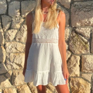 Vit klänning med spetsdetaljer - Charmig vit klänning med spetsdetaljer och volangkant. 💕 strl m/s