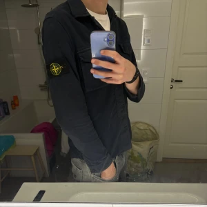 Stone Island Overshirt Navy - Säljer mitt favoritplagg då jag tyvärr växt ur den. En Stone Island overshirt i färgen Navy. Materialet är ”brushed cotton” och är väldigt likt mocka vilket gör den extra snygg och skön. Funkar fint att ha ovanpå en T-shirt eller hoodie. Storlek S. Fint skick.