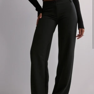 Svarta kostymbyxor - Säljer dessa lågmidjade kostymbyxor från Nelly. Jättecool modell och väldigt sköna, säljer eftersom jag behövde en mindre storlek. De är aldrig använda endast testade. (Mina egna bilder är en annan storlek alltså ej samma byxa) ❣️