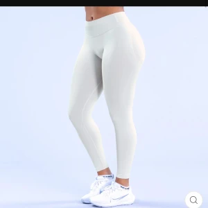 DFYNE Impact leggings  - Snygga vita leggings med medelhög midja, perfekta för träning. De har en tight passform som framhäver figuren och ger bra stöd under träningspasset. Materialet är stretchigt och bekvämt, vilket gör dem idealiska för gymmet eller yoga. Köpta för 650kr. Använda fåtal gånger då jag har många par.