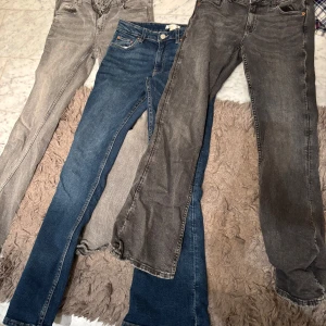 Tre par gina tricot jeans  - Säljer tre par jeans i olika färger: ett par grå, ett par blå och ett par ljusgrå. Alla har en klassisk femficksdesign och är i bootcut-stil. Perfekta för en avslappnad look. De är i storlek 158, köpta för 300 styck, säljes 100 för alla tre!