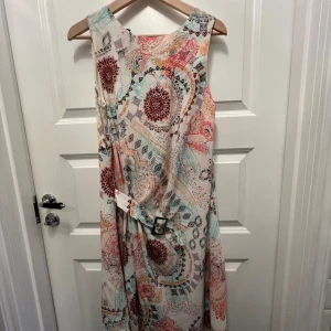 Klänning  - Storlek s, oanvänd, har ett fastsättande bälte på framsidan