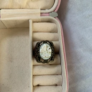 Vintage ring med snäckskalsdetalj - Säljer en superfin vintage ring med en vacker fjärilsdetalj i mitten. Ringen har en antik känsla med en intrikat metallram i bronsfärg. Perfekt för att ge en unik touch till din outfit!💕