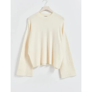 Vit stickad tröja  - Stickad tröja med boxig passform. Tröjan är vit och har lång ärm. Rund halsringning, slits i sidorna och bred ribbstickning vid ärmslut och i nederkant. Slutsåld online. Använd en hel del, tyvärr en del nopprig. 