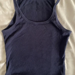 Ribbat linne - Säljer en snygg mörkblå ribbad croppad linnetopp. Perfekt för sommardagar eller som ett basplagg i garderoben. Toppen är ärmlös och har en tight passform, storlek S💗