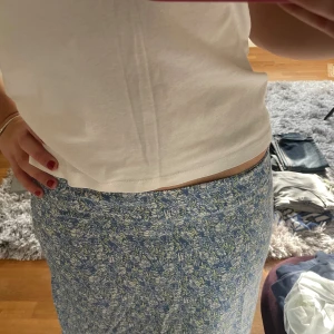 Blommig långkjol i blått och vitt - Säljer en superfin långkjol med blommigt mönster i blått och vitt. Kjolen har en bekväm passform och är perfekt för både vardag och festliga tillfällen. Den är gjord i ett lätt och luftigt material, vilket gör den idealisk för vår och sommar. Passar perfekt med en enkel topp eller blus! Vintage från Esprit!