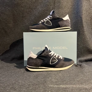 Philippe Model trainers  - Snygga Philippe Model sneakers i blått och vitt med vita detaljer. Skorna har en stilren design med snörning och en bekväm sula. Perfekta för en trendig look. Skick 8/10 Stl 41 men passar 42 OBS!!! Box tillkommer ej 