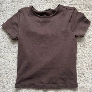 Brun topp - Brun tight T-shirt o stretchigt material💕har en annons uppe med en i samma modell fast rosa! Säg till om du vill köpa båda tillsammans så kan det bli billigare. Tröjan går typ precis ner till naveln