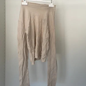 Beige ribbad tröja från Grunt - Säljer en stilren beige ribbad tröja från Grunt. Tröjan har långa ärmar och en mjuk, bekväm passform. Perfekt för en avslappnad look. Passar bra till jeans eller kjol.