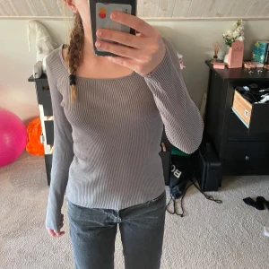 Grå ribbad topp från Samsa Collection - Snygg grå ribbad topp från Samsa Collection med långärmad design. Perfekt för en stilren look, med en fyrkantig halsringning som ger en modern touch. Passar bra till både jeans och kjol. Inte andvänd många gånger. Pris går att diskutera💕