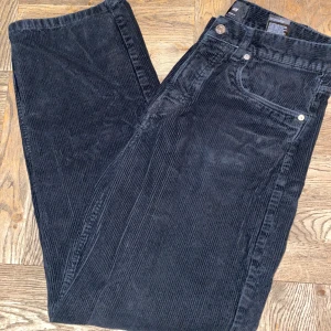 Svarta manchesterbyxor från H&M - Snygga svarta manchesterbyxor från H&M med loose fit. Perfekta för en avslappnad stil. Byxorna har en klassisk design med knappar och dragkedja framtill.