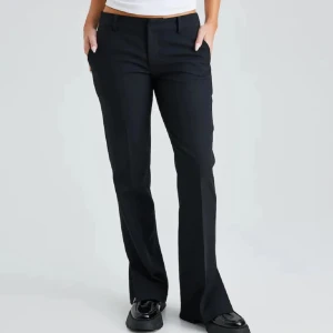 Vera petite kostymbyxor från BikBok - Svarta kostymbyxor från BikBok med bootcut-stil. De är petite, så passar folk med korta ben i modellen Vera. Byxorna har en slitsdetalj vid fållen. Lågmidjade. Aldrig använda av mig men köpte här på Plick, fint skick. Jag är 164 cm lång och dom är korta på mig. Om du har frågor eller vill ha mer bilder kontakta mig🩷