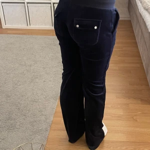 Marinblå mjukisbyxor från Juicy Couture - Säljer ett par marinblå mjukisbyxor från Juicy Couture. Byxorna har en bekväm passform med snörning i midjan och fickor med knappar bak. Perfekta för en avslappnad stil. Sparsamt använda! Skriv privat om ni vill ha fler bilder eller har frågor 💙