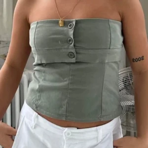 Grön tubtopp med knappar - Snygg grön topp i oanvändt skick, lapp finns kvar, säljes då den inte passade mig💕💕