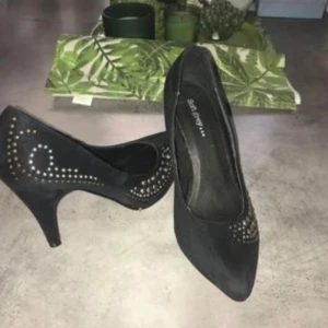Svarta pumps med nitar - Snygga svarta pumps med spetsig tå och klack. Skorna är dekorerade med nitar som ger en tuff look.  Känns som mocka i materialet. Märket är Soft Grey som jag endast provat inomhus jag köpte dem för 699kr från Ellos. Jätte fina men pga av viktnedgång så har dem blivit stora. Dem är i strl 40