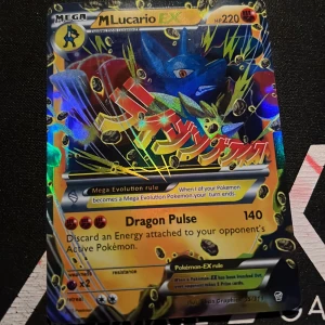 Pokémonkort M Lucario EX - Säljer ett Pokémonkort med M Lucario EX. Kortet har en färgglad och glittrig design med texten 'Dragon Pulse' och 'Mega Evolution rule'. Perfekt för samlare eller Pokémon-entusiaster!