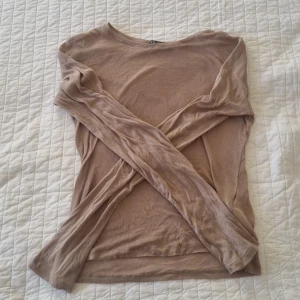 Beige långärmad topp från Zara - Säljer en stilren beige långärmad topp från Zara. Perfekt för lager-på-lager eller som den är. Tillverkad i ett lätt och bekvämt material. Den är tunn och ganska genomskilning. VÄDLIGT LIK INTEMUSSMI TRÖJAN. Jag möts bara upp!!!!