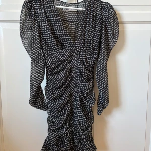 Mönstrad klänning från Zara - Snygg klänning från Zara med vita prickar och rynkade detaljer. 