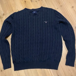 Marinblå stickad tröja från GANT - Säljer en snygg stickad tröja från Gant. Storlek S. Väldigt bra skick på tröjan, inga defekter. Priser kan alltid diskuteras