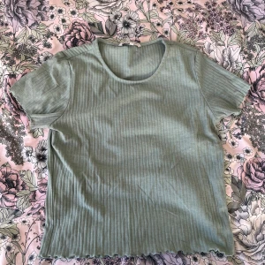 Grön ribbad t-shirt från ONLY - Säljer en stilren grön ribbad t-shirt från ONLY. Den har korta ärmar och en rund halsringning. Storlek L, upplever den dock som lite kortare.