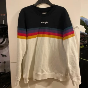 Flerfärgad tröja från Wrangler - Säljer en snygg flerfärgad tröja från Wrangler. Tröjan har en svart överdel med färgglada ränder i blått, rosa, lila, rött och gult. Den är långärmad och har en bekväm passform. Perfekt för en avslappnad stil! I använd men bra skick. Storlek L. Säljs för 200kr men pris är ej hugget i sten. Hör av er med frågor.                                                                          Mvh//Alvin