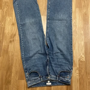 Blå jeans från H&M - Blåa jeans från H&M i vanligt, klassiskt snitt. Det är ett par helt vanliga jeans, inget särskilt eller unikt med dem. De är i gott skick och har aldrig använts. Priset kan diskuteras om du är intresserad.