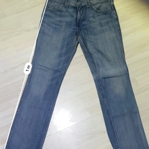 Unika levi’s 511 slim - Snygga blå jeans från Levi's med klassisk femficksdesign och en bekväm passform. De har en traditionell knappgylf och är tillverkade i slitstarkt denim. Perfekta för en avslappnad stil.