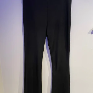 Svarta byxor flared  - Snygga svarta byxor med en tight passform. Perfekt för en lätt uppklädd dag. Byxorna har en kostymbyxor känsla i sig och i materialet. Har ett lagom stretchigt material. 