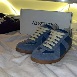 Blå sneakers från Hey Studios - Snygga blå sneakers från Hey Studios. skorna är i otroligt fint skick och har nästan aldrig använts. modellen på skon är inspirerad av Maison Margiela och är perfekt alternativ till det som inte vill lägga så mycket pengar för att öppna samma stil, skorna är gjorda i Italien och har väldigt hög kvalitet. har du några frågor angående pris eller annat så är det bara att höra av dig och jag är väldigt intresserad av att göra biten. MVH Oscar_resell
