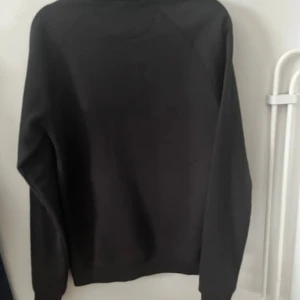 Svart tröja - Säljer en stilren svart tröja med långa ärmar. Perfekt för en enkel och klassisk look. Tröjan har en rund hals och är tillverkad i materialet bomull för extra komfort. Köpt för 350kr säljer för endast 150kr 