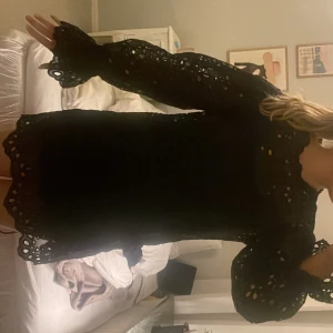 Svart klänning med spetsdetaljer -  svart klänning med långa ärmar i spets med underklänning  