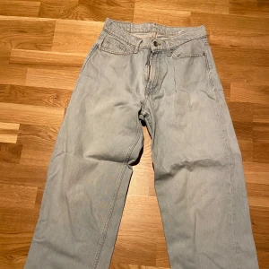 Ljusblå jeans från Valient - Säljer ett par ljusblå jeans från Valient i storlek XS. Byxorna har en klassisk design med fem fickor och knappgylf. Perfekta för en avslappnad stil.