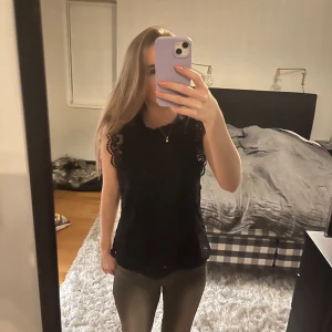 Svart spetslinne - svart spetslinne med vackra spetsdetaljer på ärmarna. 