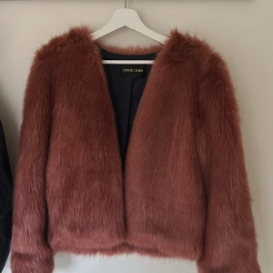 Rosa fuskpälsjacka från Stine Goya - Säljer en snygg rosa pälsjacka från Stine Goya. Jackan har en mjuk och fluffig yta med långa ärmar och en stilren design. Perfekt för fest. 🧥✨