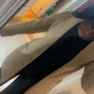 Beige kappa  - Beige kappa från OASIS är 170 lång.  Knapparna är lite lösa  men funkar fortfarande perfekt. Säljer billigt.