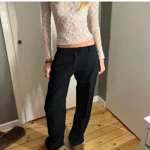 Svarta kostymbyxor - Snygga svarta kostymbyxor med en klassisk passform. De har en rak stil och är perfekta för en stilren look. Byxorna har en midwaist och är tillverkade i ett bekvämt material.