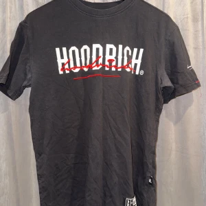 Svart t-shirt och svarta shorts från Hoodrich - Snygg svart t-shirt och svarta shorts från Hoodrich med vit och röd logga på bröstet och ryggen. T-shirten är S men känns som M och shortsen är XL men känns som L