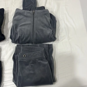 Grå mjukisbyxor och hoodie - Säljer ett set med grå mjukisbyxor och matchande hoodie. Byxorna har en bekväm passform med snörning i midjan och hoodien har dragkedja framtill. Perfekt för en avslappnad stil.