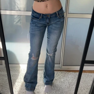 Lågmidjade Bootcut jeans med hål - Sjukt snygga lågmidjade jeans med hål. Väldigt stretchiga. Innerbenslängd: 80 midjemått: 36 stretch till 42. köp sker via köp nu, jag postar inom 24h.kvar tills markerad såld 
