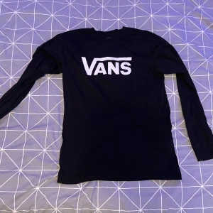 Svart långärmad tröja från Vans - Säljer en svart långärmad tröja från Vans med deras ikoniska logga i vitt på framsidan. Tröjan är i bra skick och superbekväm att ha på sig. Använd ett fåtal gånger. Står att det är storlek XL men den sitter som en s/m. 