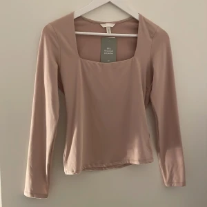 Långärmad tröja - Beige långärmad tröja. Ny, oanvänd . Fyrkantig urringning.