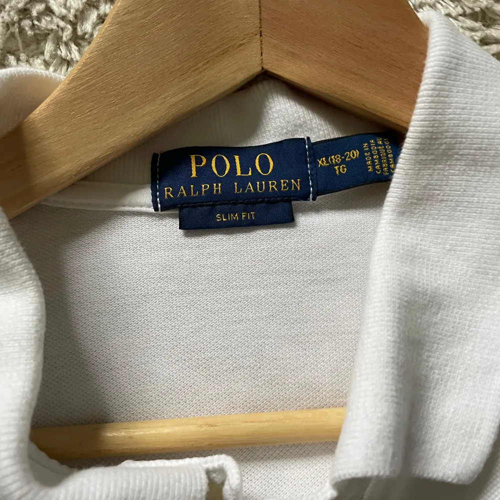 Säljer en klassisk vit pikétröja från Ralph Lauren i slim fit. Tröjan har korta ärmar och en liten broderad logga på bröstet. Perfekt för en stilren och avslappnad look. Passar både till vardags och fest!. Tröjor & Koftor.