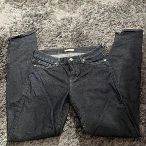 Mörkblå jeans från Wera Stockholm - Säljer ett par snygga mörkblå jeans från Wera Stockholm. De har en klassisk femficksdesign med knappar och dragkedja framtill. Perfekta för både vardag och fest!