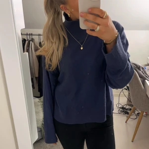 Mörkblå stickad tröja - Super söt stickad tröja med högre krage från bikbok. Tröjan har fått ett litet hål i baksidan på kragen annars är den i väl skick☺️