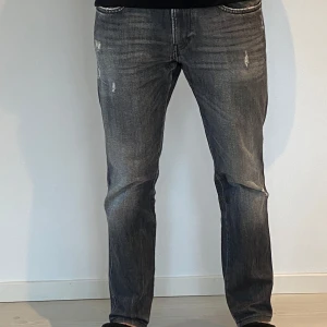 Replay Anbass - Snygga grå jeansbyxor med en cool slitningseffekt. De har en klassisk femficksdesign och en rak passform som ger en avslappnad look. Perfekta för en casual stil. Använda ett fåtal gånger därmed väldigt bra skicka storlek 31/32