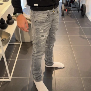 Gråa jeans med slitningar  - Gråa slimfit jeans med slitningar från Jack and Jones