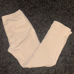 Beige linnebyxor  - Säljer ett par bekväma beige linneabyxor med elastisk midja och bakficka. Perfekta för en avslappnad stil. Byxorna har en liten fläck på benet. Hör gärna av er vid frågor:)